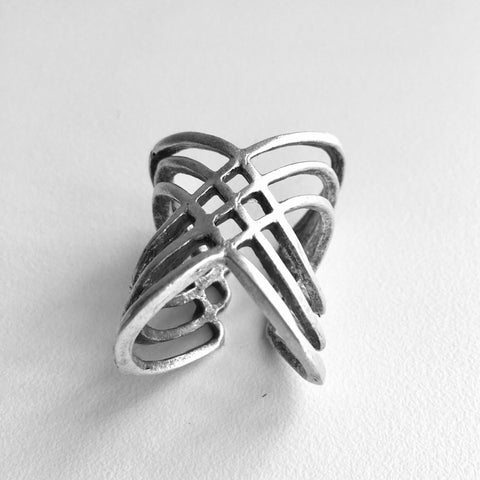 Front view of  Multi-cross mixed metal silver colored Turkish made ring with an adjustable band. Lightweight statement ring  with 1 inch height on the top wave, with a center half inch. A wave of bands with a woven 4 diamond shaped stamp in the middle.  Usual and Unique styled rings made just for you.