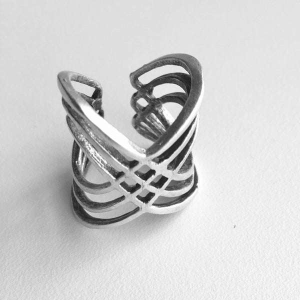 top view of  Multi-cross mixed metal silver colored Turkish made ring with an adjustable band. Lightweight statement ring  with 1 inch height on the top wave, with a center half inch. A wave of bands with a woven 4 diamond shaped stamp in the middle.  Usual and Unique styled rings made just for you.