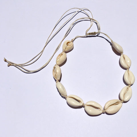 WHITE COWRIE SHELL CORD NECKLACE STRUNG ON A NATURAL COLORED CORD AND EASY KNOT CLOSURE FOR ADJUSTING THE LENGTH. GREAT NECKLACE FOR SUMMER AND ISLAND LIFE. VERY LIGHT AND EASY TO WEAR. MADE IN TURKEY FOR US.
